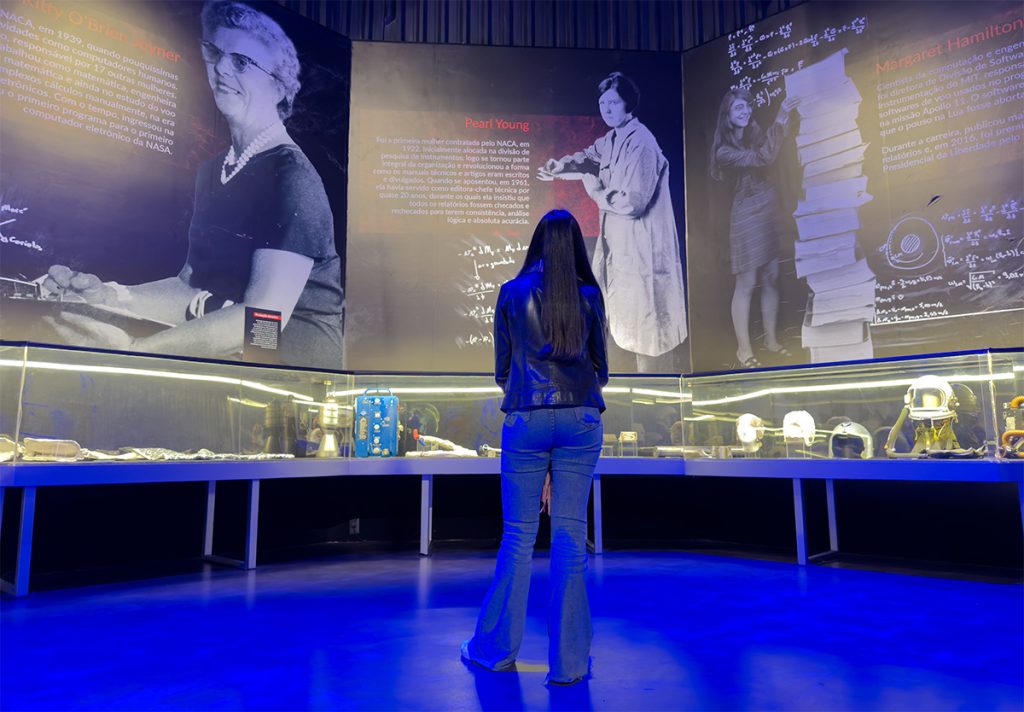 Alessandra do Aventurando Tchê observando exposição de mulheres no Space Adventure Canela