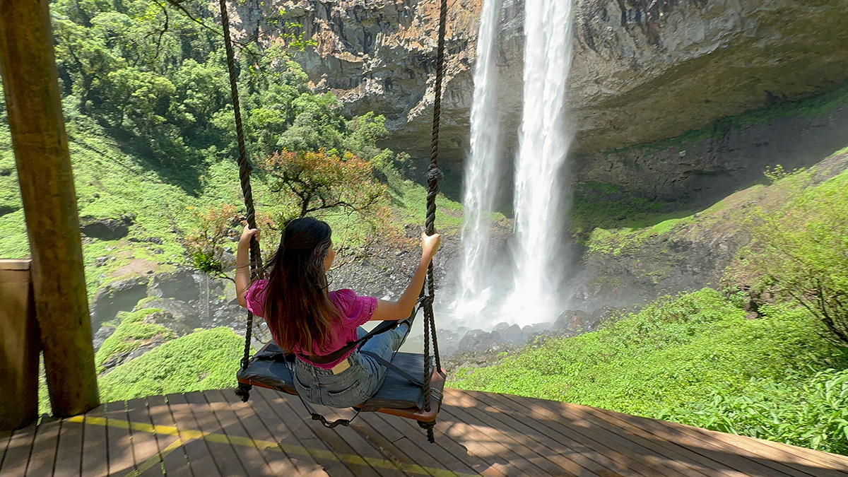 Alessandra do Aventurando TchÃª no balanÃ§o infinito do PÃ© da Cascata do Caracol em Canela