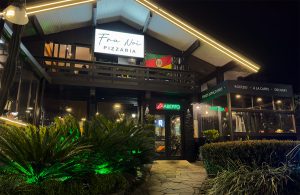 Fachada noturna da Fra Noi Pizzaria em Canela