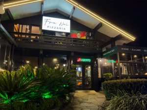 Fachada noturna da Fra Noi Pizzaria em Canela