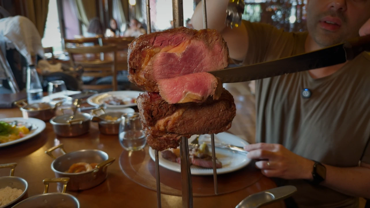 Churrascaria Chama de Fogo Gramado — Corte de carne grelhada sendo fatiado na tábua de madeira.