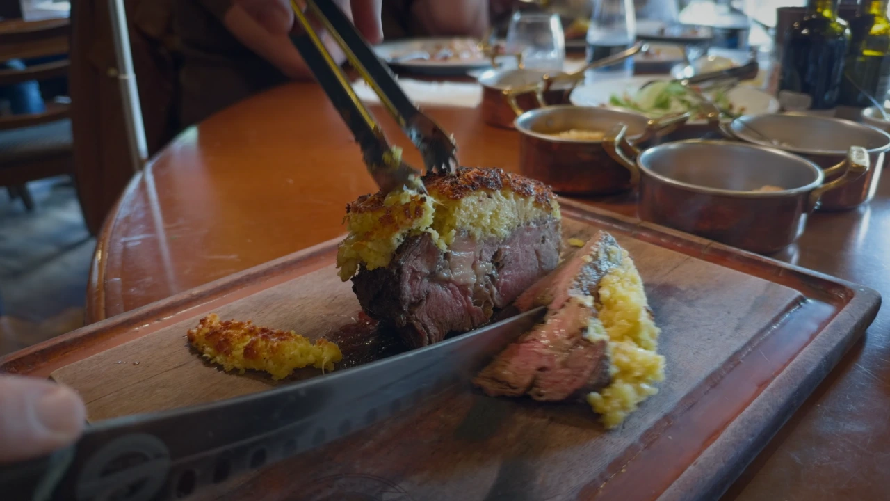Churrascaria Chama de Fogo Gramado — Fatiamento de entrecô com crosta gratinada em tábua de madeira.